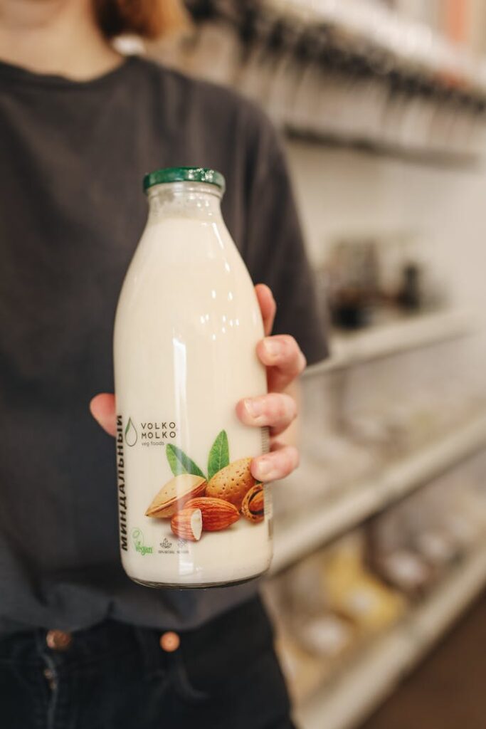 Woman holding a glass bottle of almond milk, perfect for a vegan and lactose-free diet.